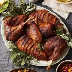 Thanksgiving turkey on a platter with sides around it.