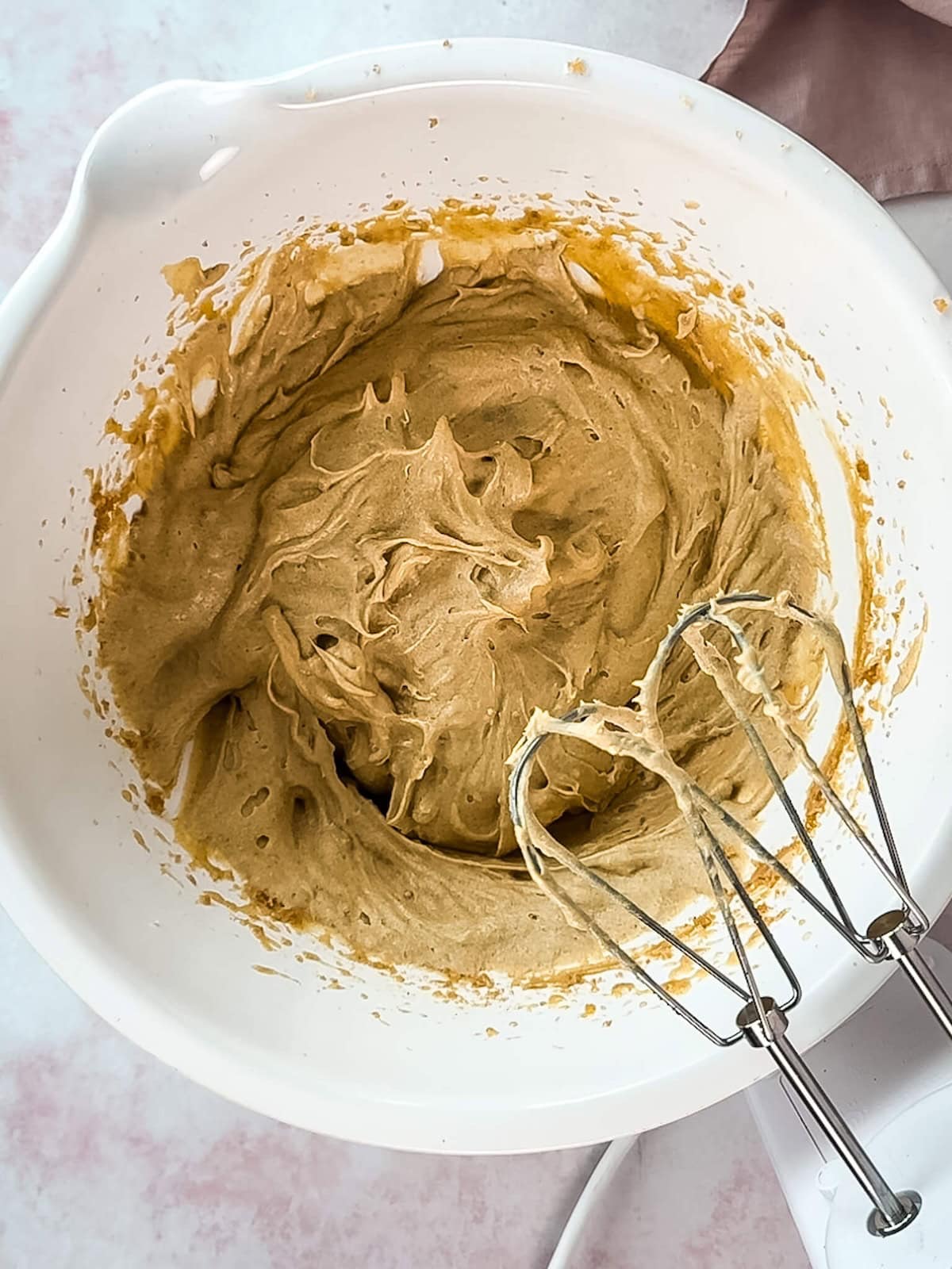 Blondie batter in a white mixing bowl after eggs have been blended in.