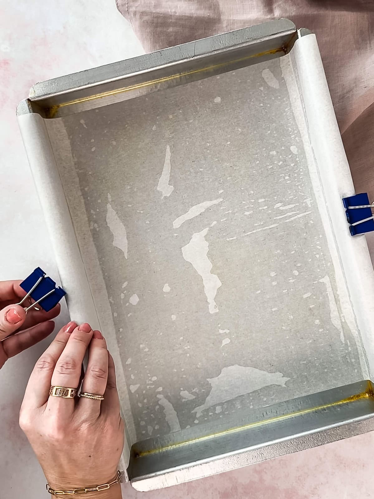 Prepping a baking pan with parchment paper.