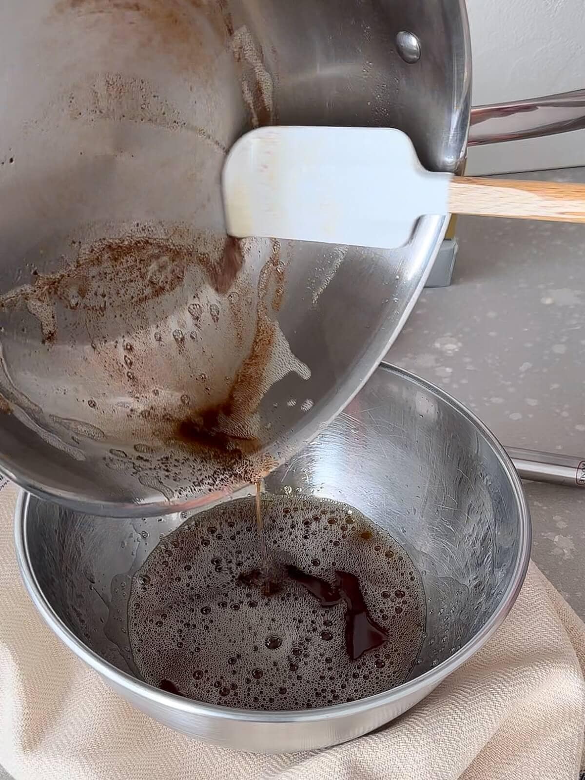 Scraping remaining browned butter from pan to a bowl.