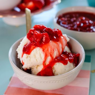 A bowl of ice cream covered in strawberry ice cream sauce.