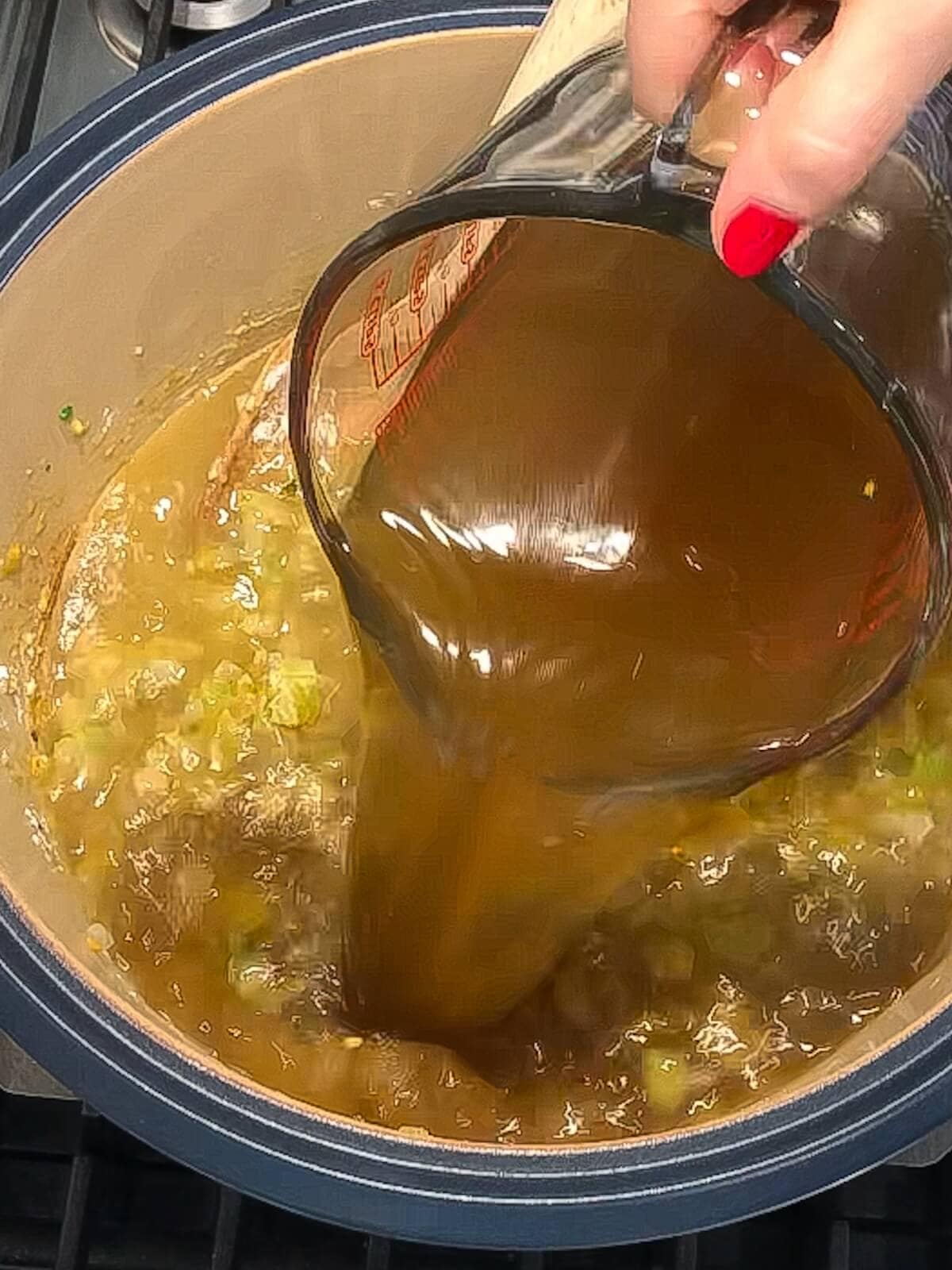 Broth being poured into the base of vegetarian white chili.