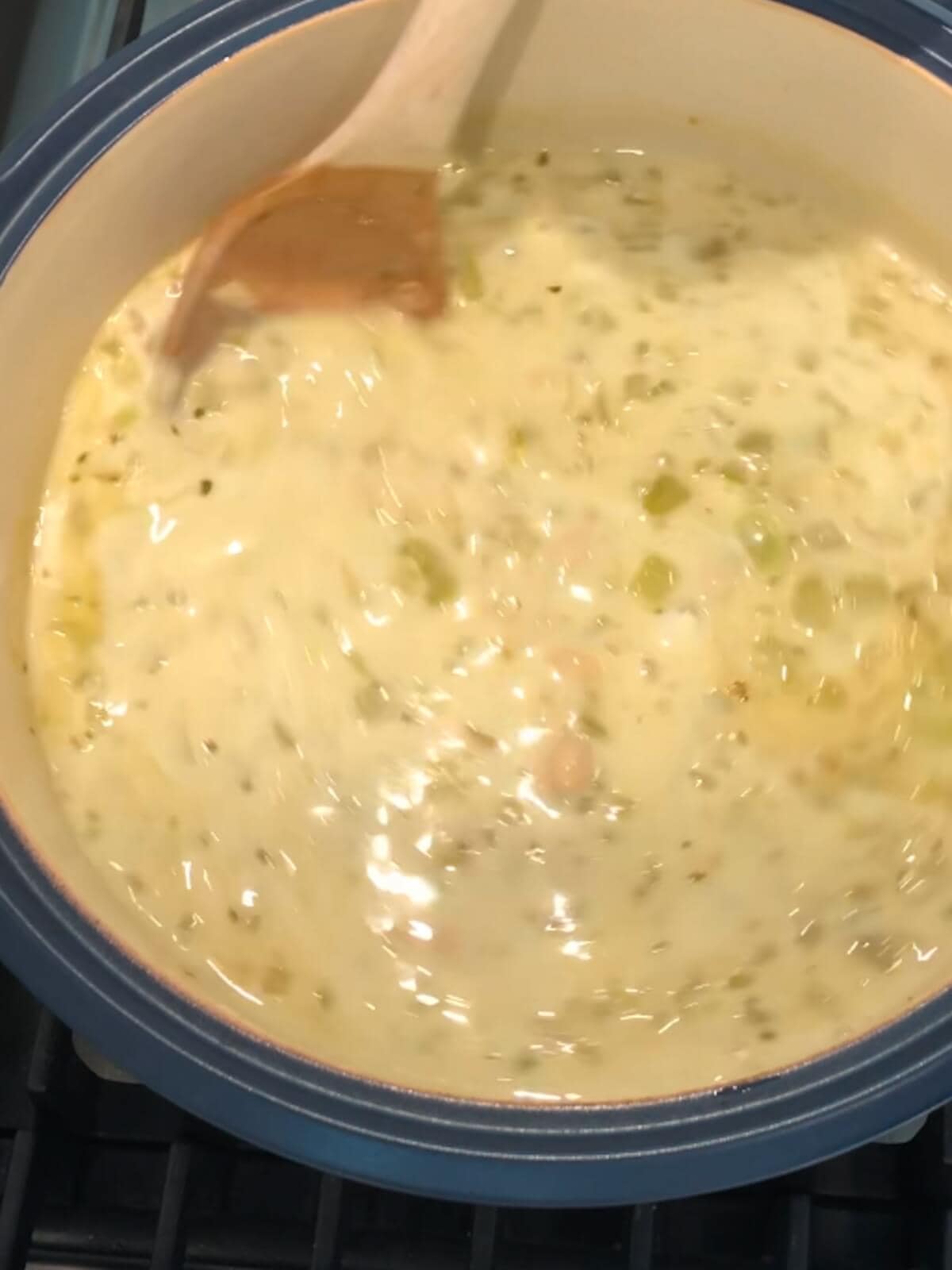 Stirring the vegetarian white chili together to fully incorporate the cream.