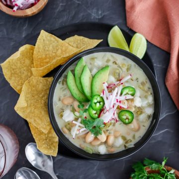 Top view of a bowl of vegetarian white chili with toppings.