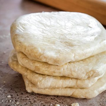 Four discs of plastic wrapped pie crust.