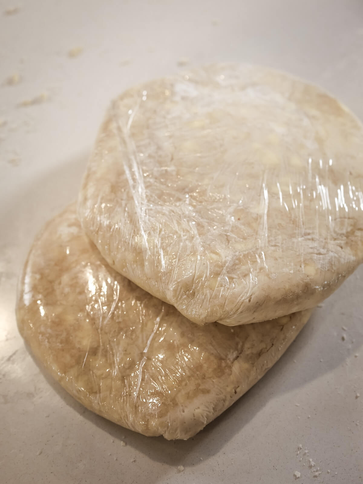Two discs of plastic wrapped pie crust.
