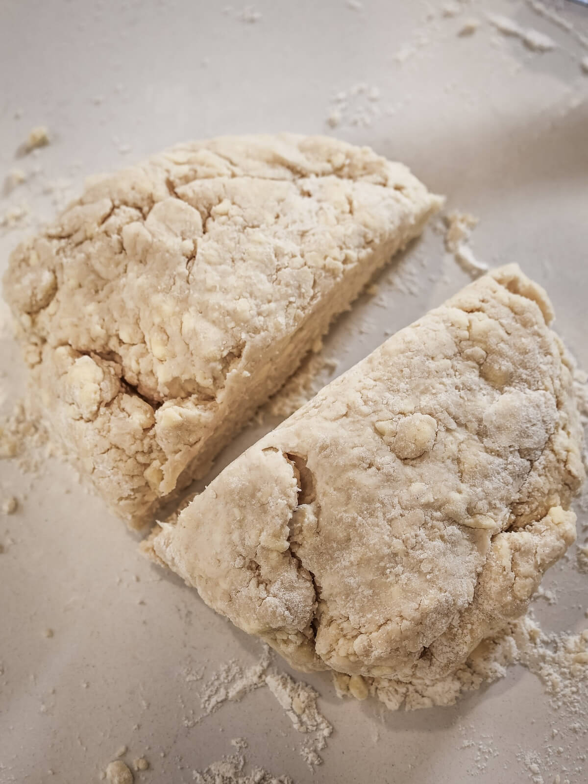 A lump of crumbly pie crust that has been divided in half.