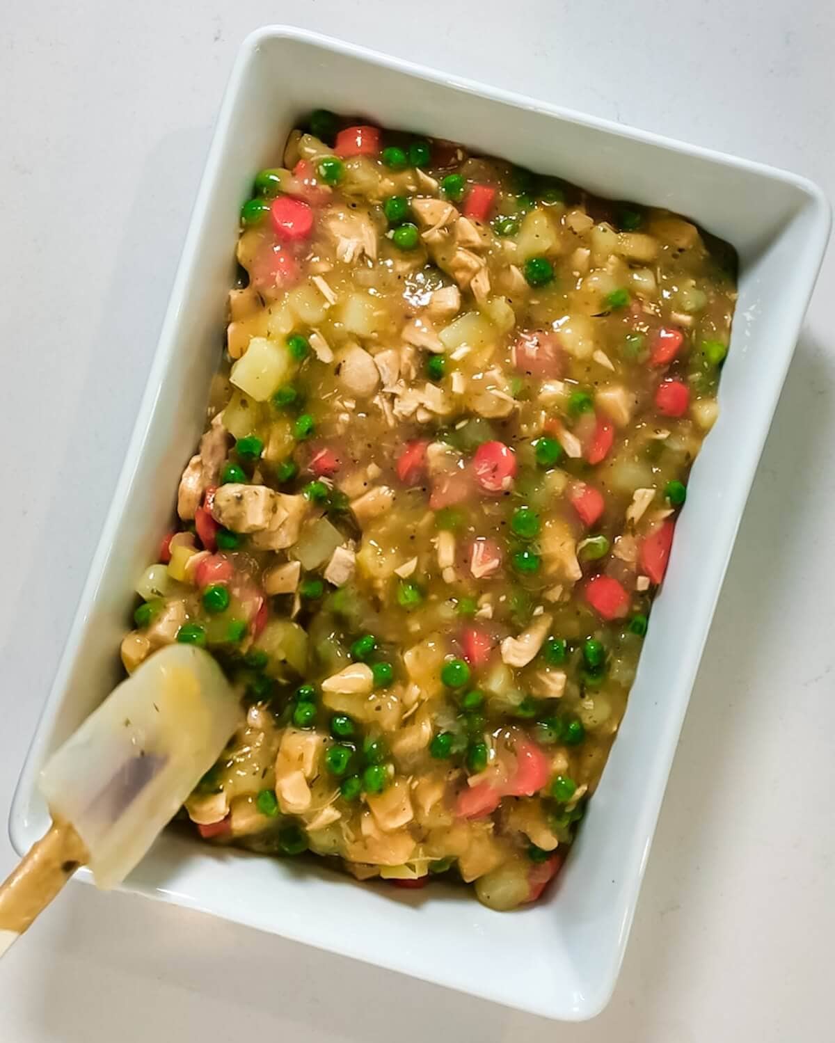 Turkey pie filling spread into a baking dish.