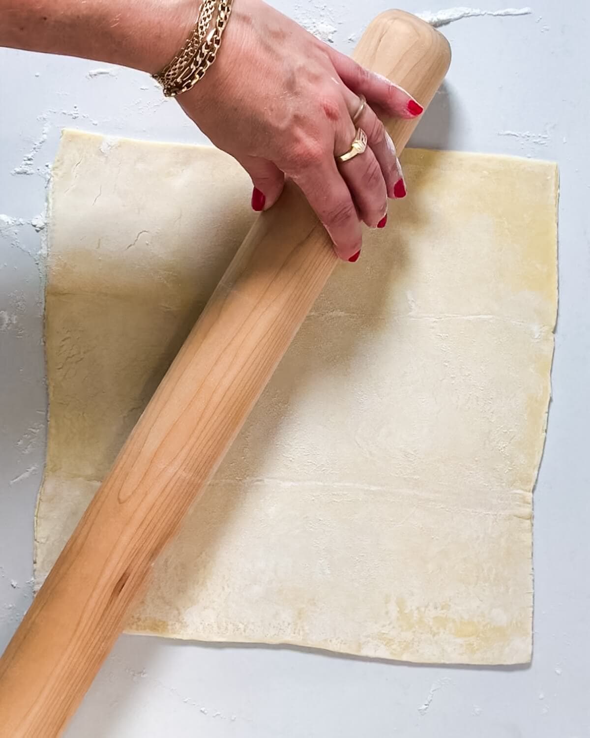 Hand rolling out puff pastry.