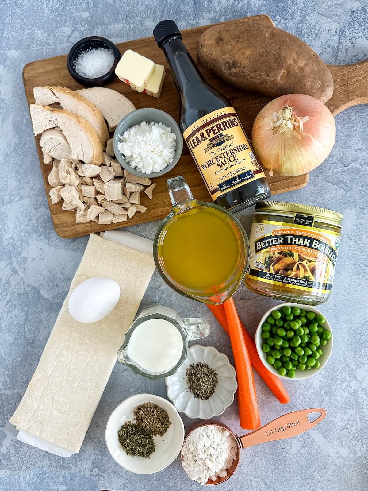 Ingredients for turkey pot pie with puff pastry including turkey, salt, butter, cornstarch, worcestershire sauce, onion, potato, peas, carrots, broth, milk, seasonings, flour, egg, and puff pastry dough.