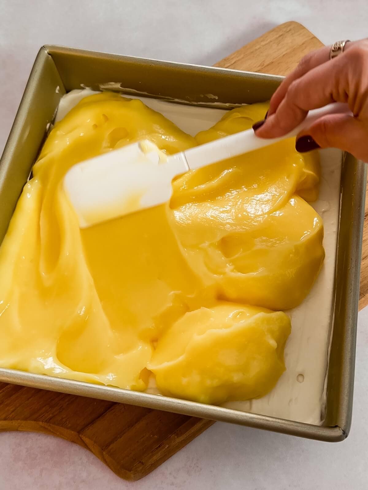 Spread lemon curd over cream cheese layer and return to the fridge covered.