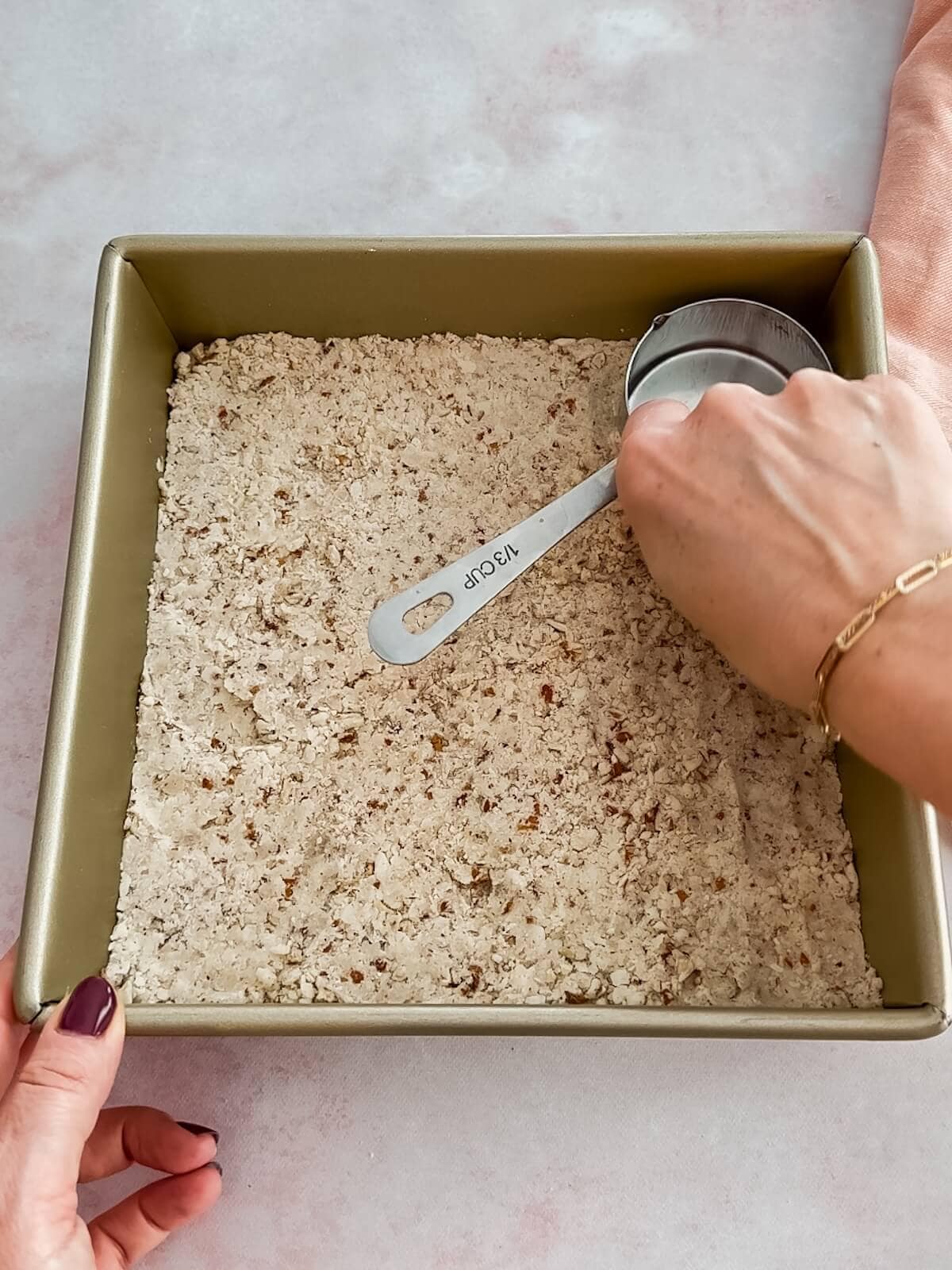 Pressing crust into pan firmly with the bottom of a measuring cup so it is even and compact.