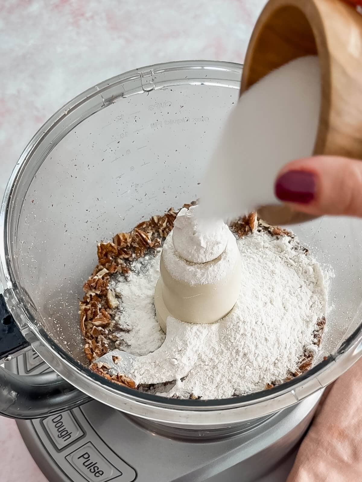 Adding dry ingredients like flour and sugar to crust mixture in the food processor for lemon lush.
