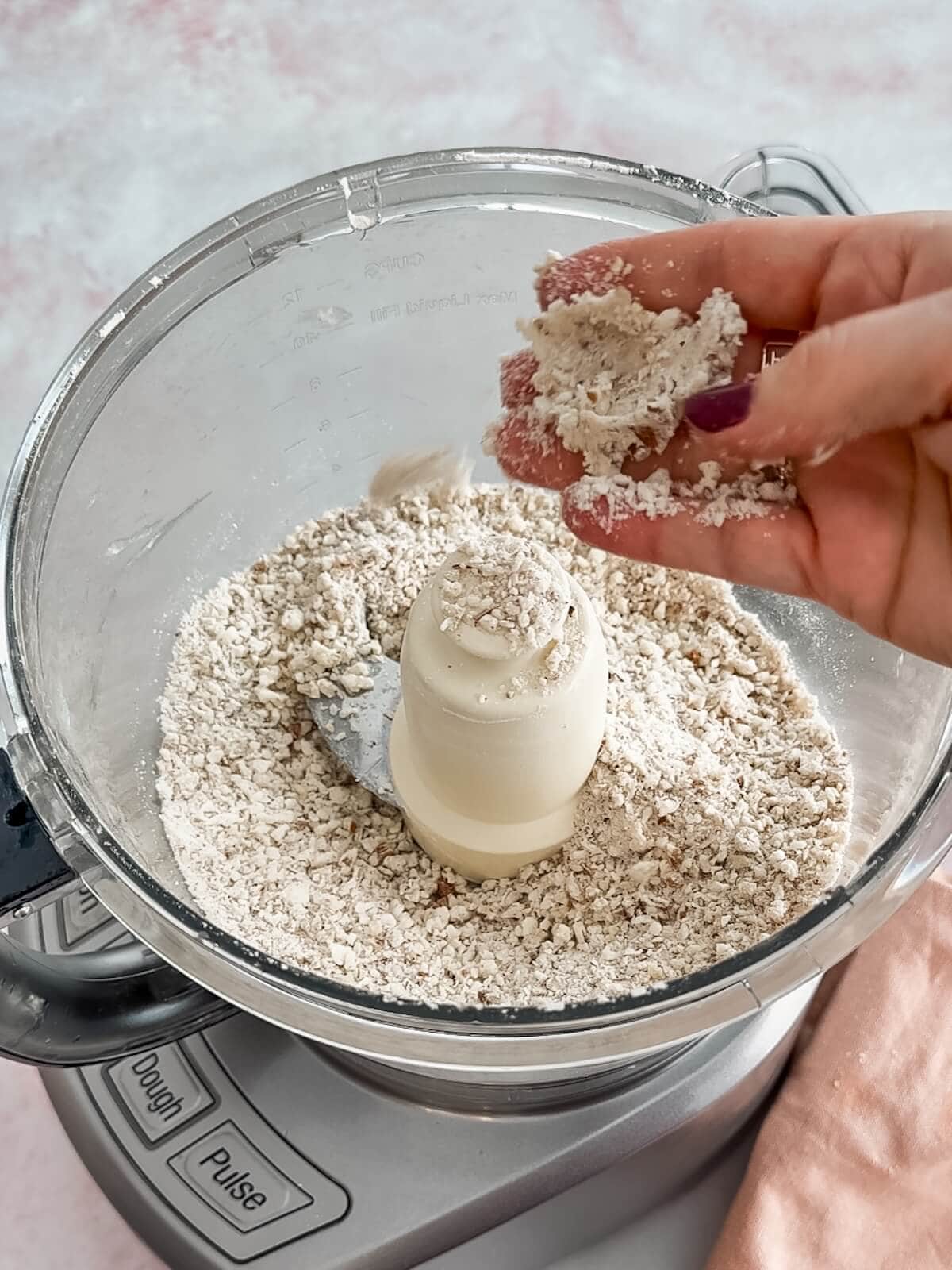 Checking the texture of the crust crumbs for lemon lush by squeezing some of it in your fingers.