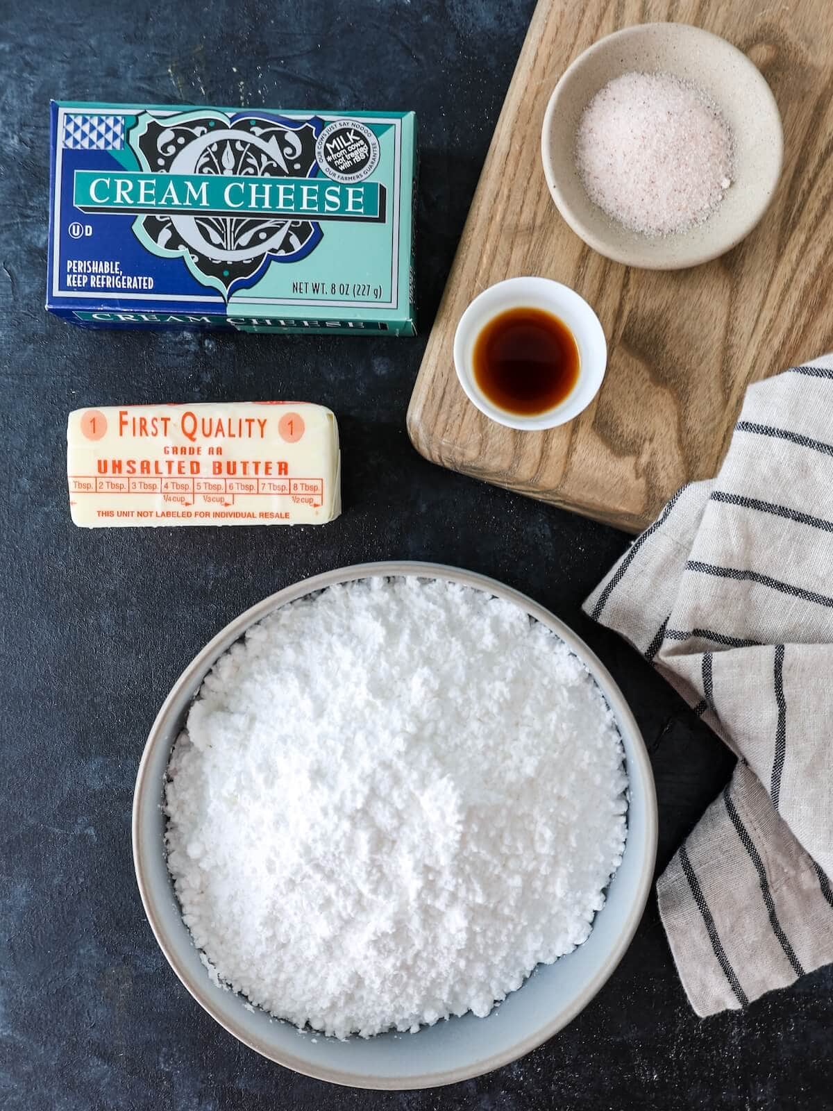 Ingredients for cream cheese frosting including confectioners' sugar, butter, vanilla, salt, and cream cheese.