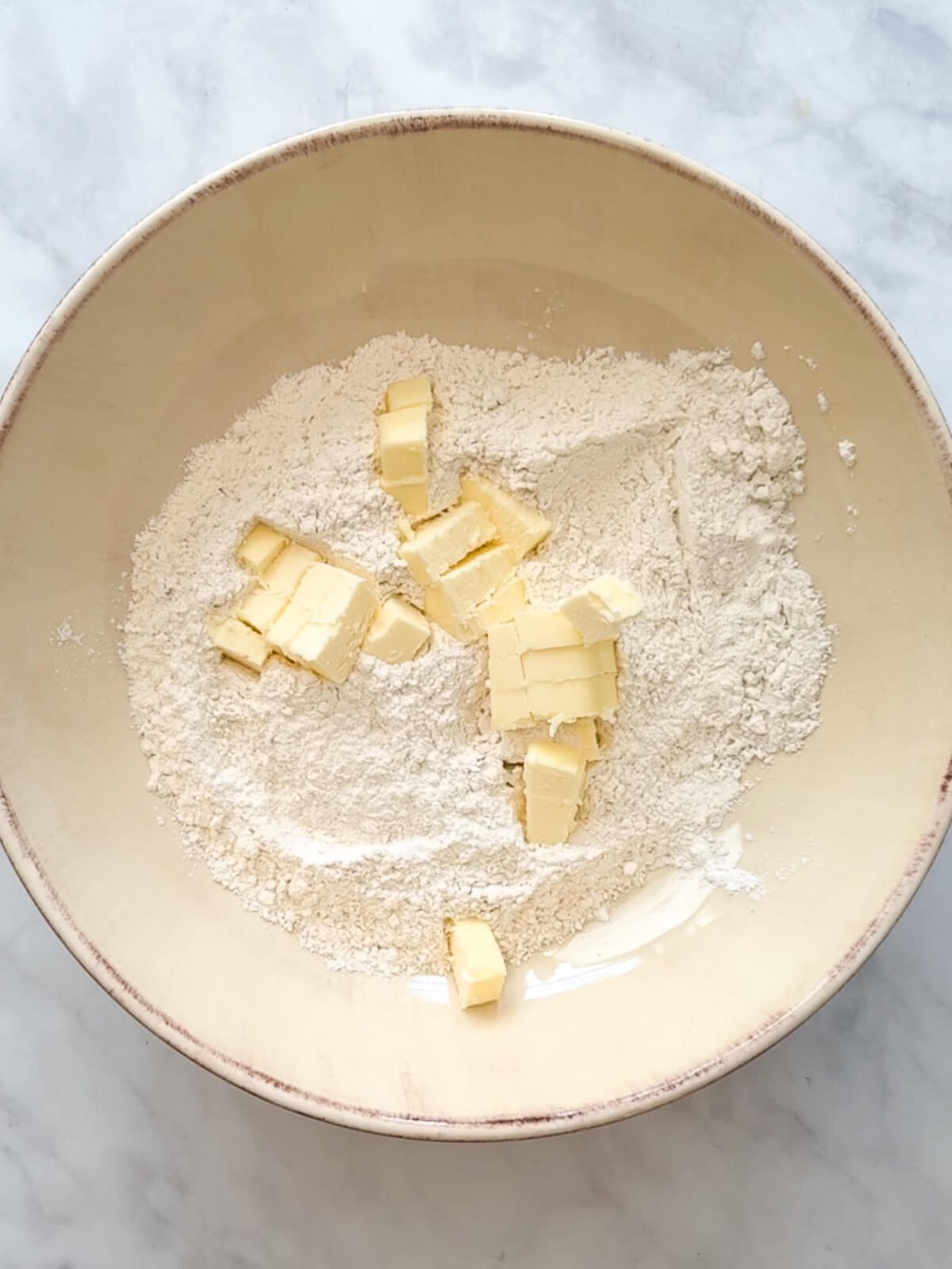 butter and dry ingredients in a bowl ready to make biscuits.