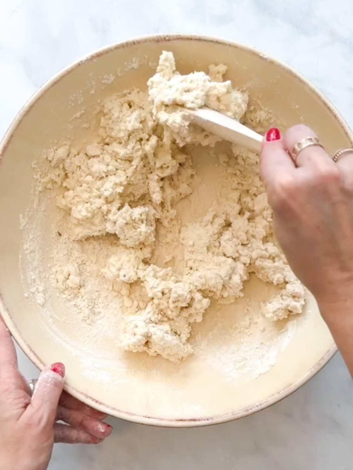 Mixing biscuit dough and it looks shaggy and wet.