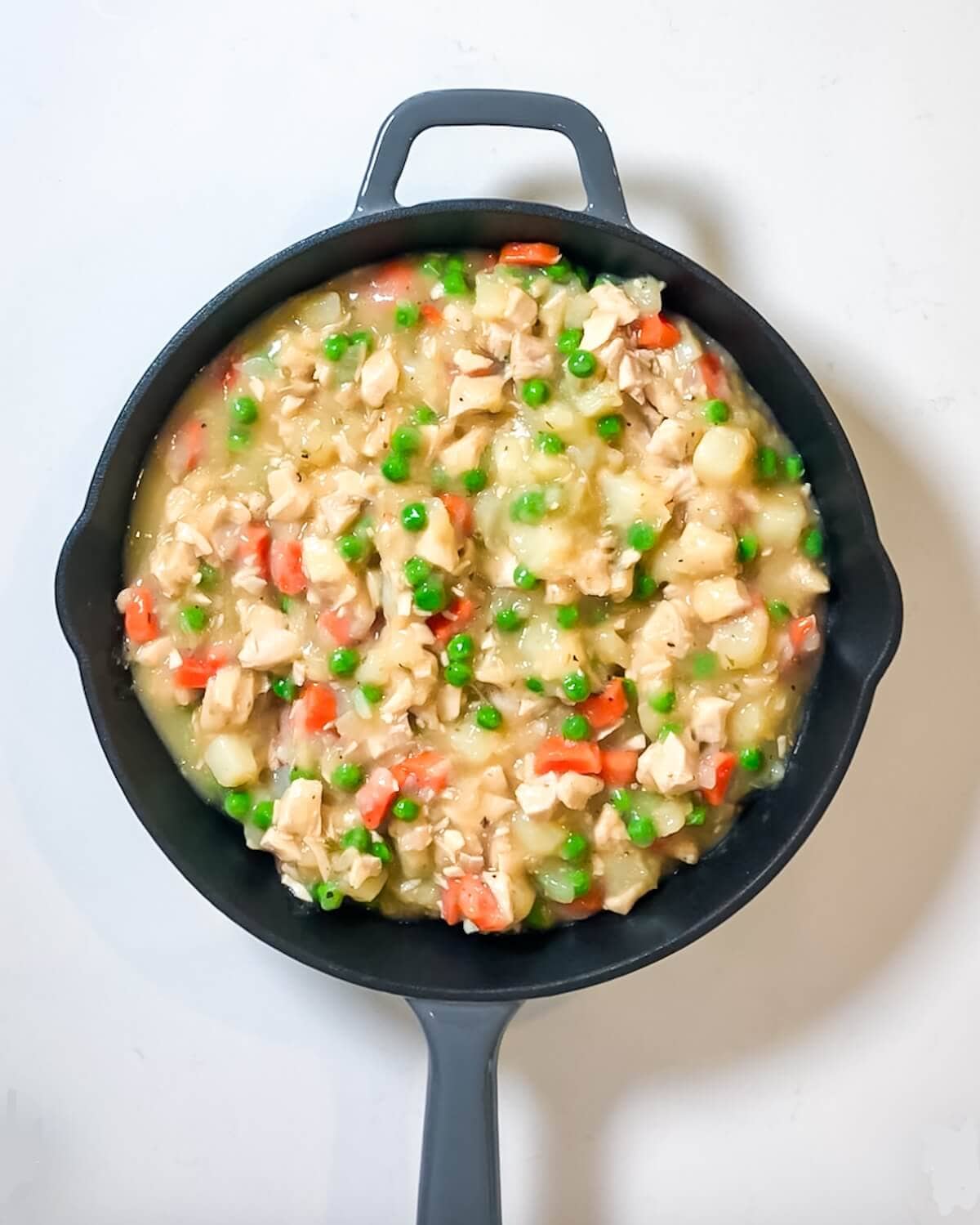Turkey pot pie with biscuit topping in pan ready for topping.