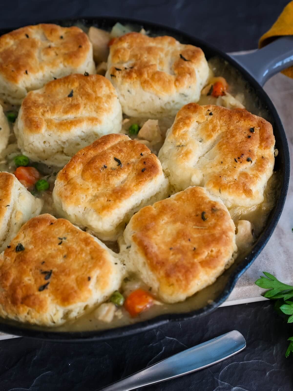Turkey pie with biscuit topping in a cast iron skillet ready to be served.