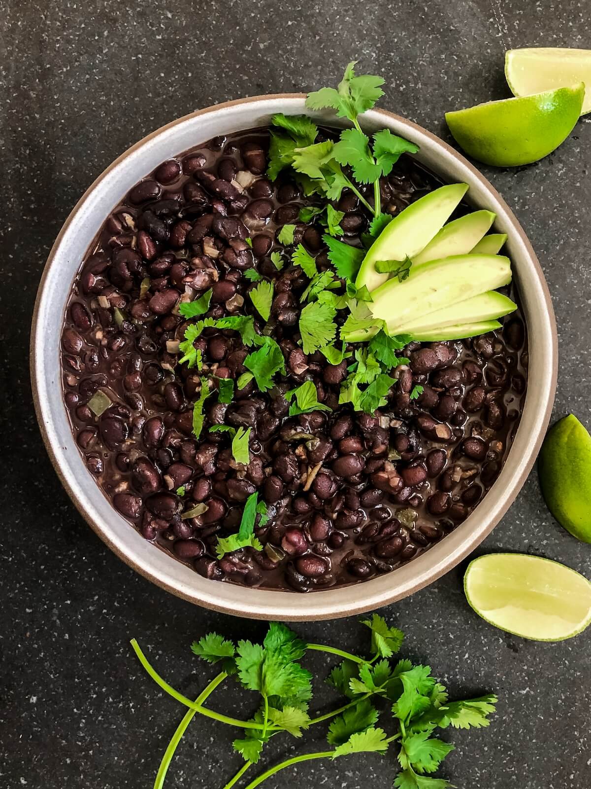 creamy black beans in a bowl with toppings.