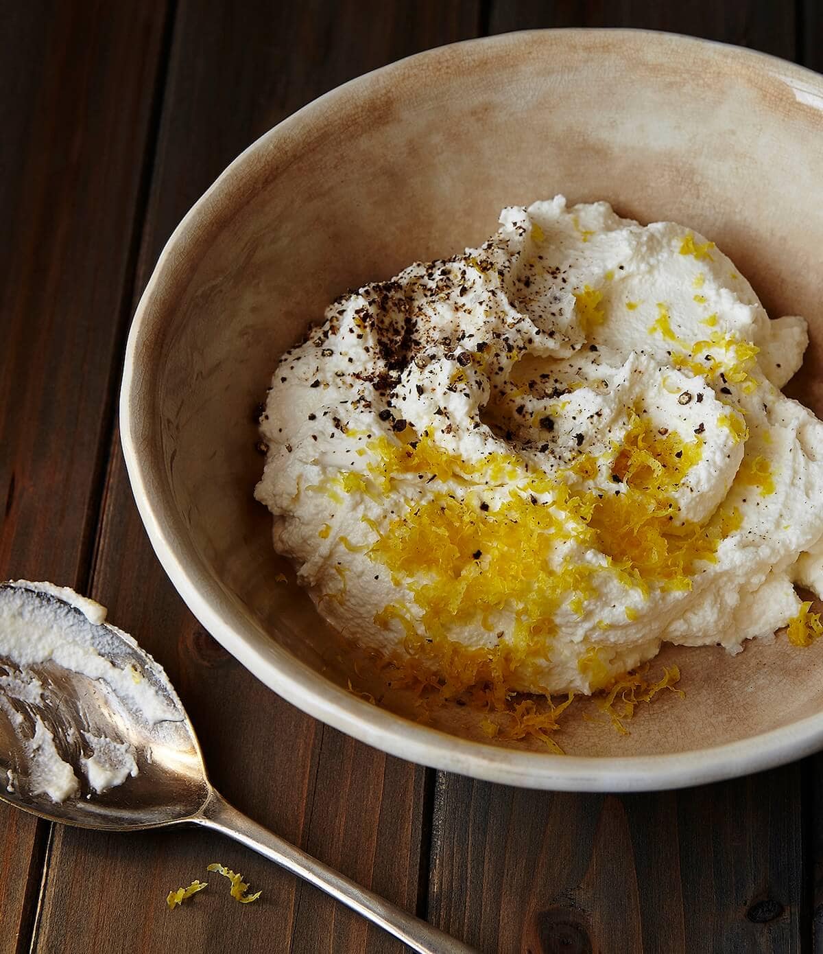 Mixing ricotta with lemon and pepper for ricotta topping.
