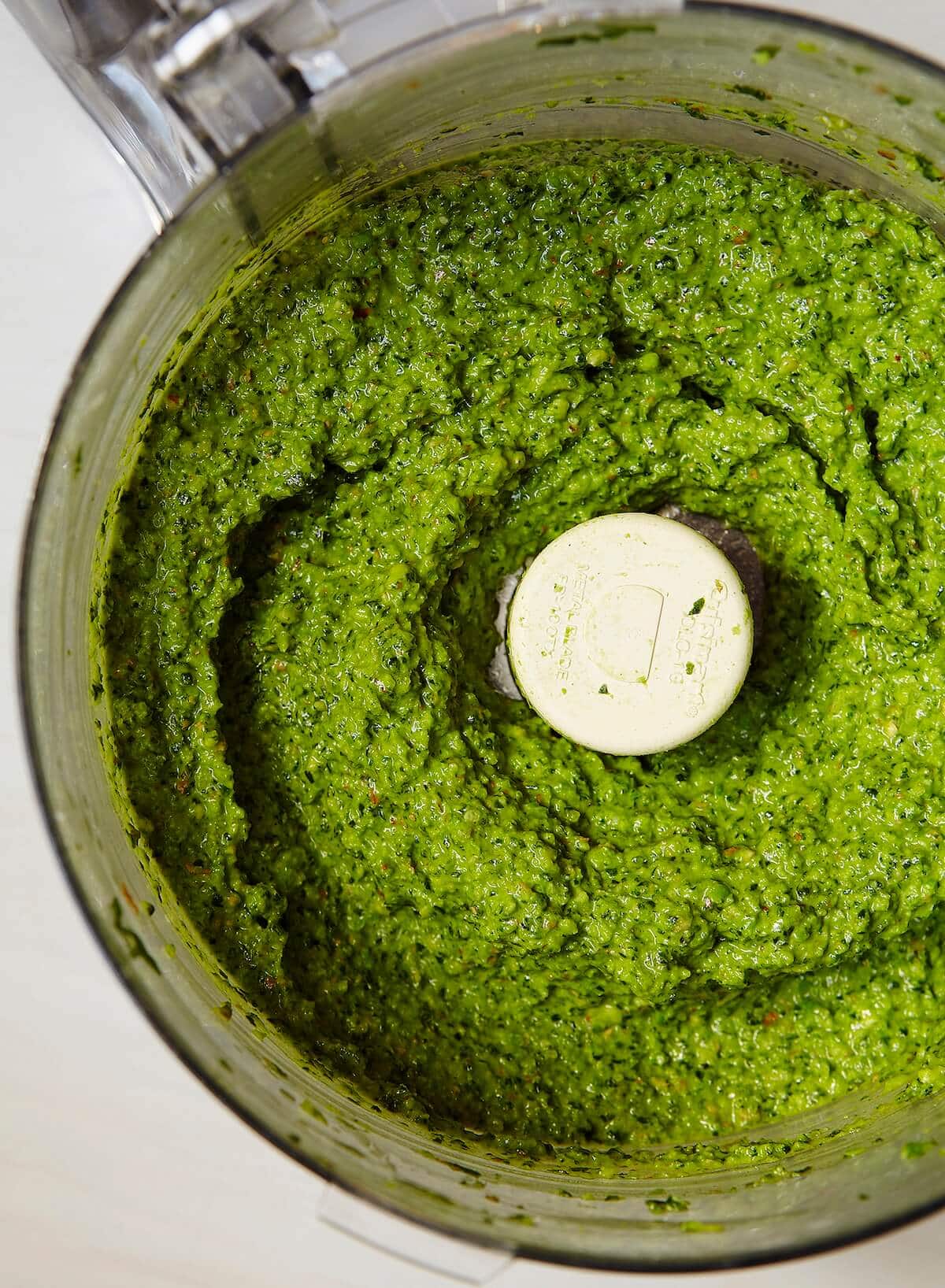 mixed pesto with almonds, basil, garlic, and spinach with peas, in a food processor