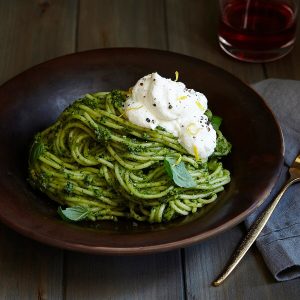 pesto pasta with lemon ricotta on dark background in a dark bowl feature image.