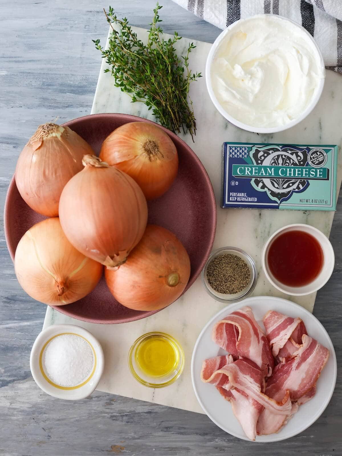 ingredients for caramelized onion dip including bacon, thyme, onions, sour cream, cream cheese, pepper, oil, vinegar, and salt.