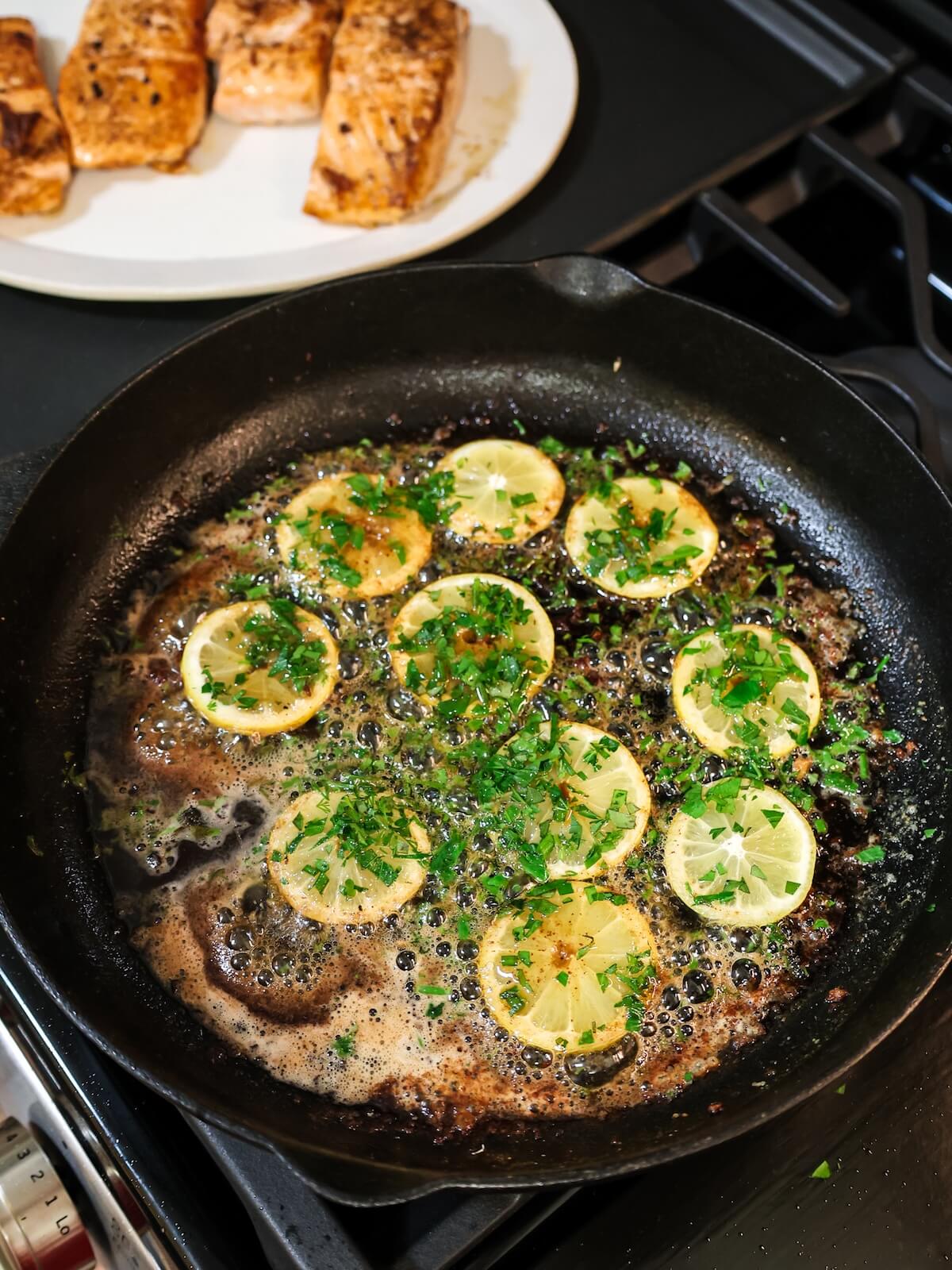 cooking lemon slices in butter and herbs for lemon butter salmon.