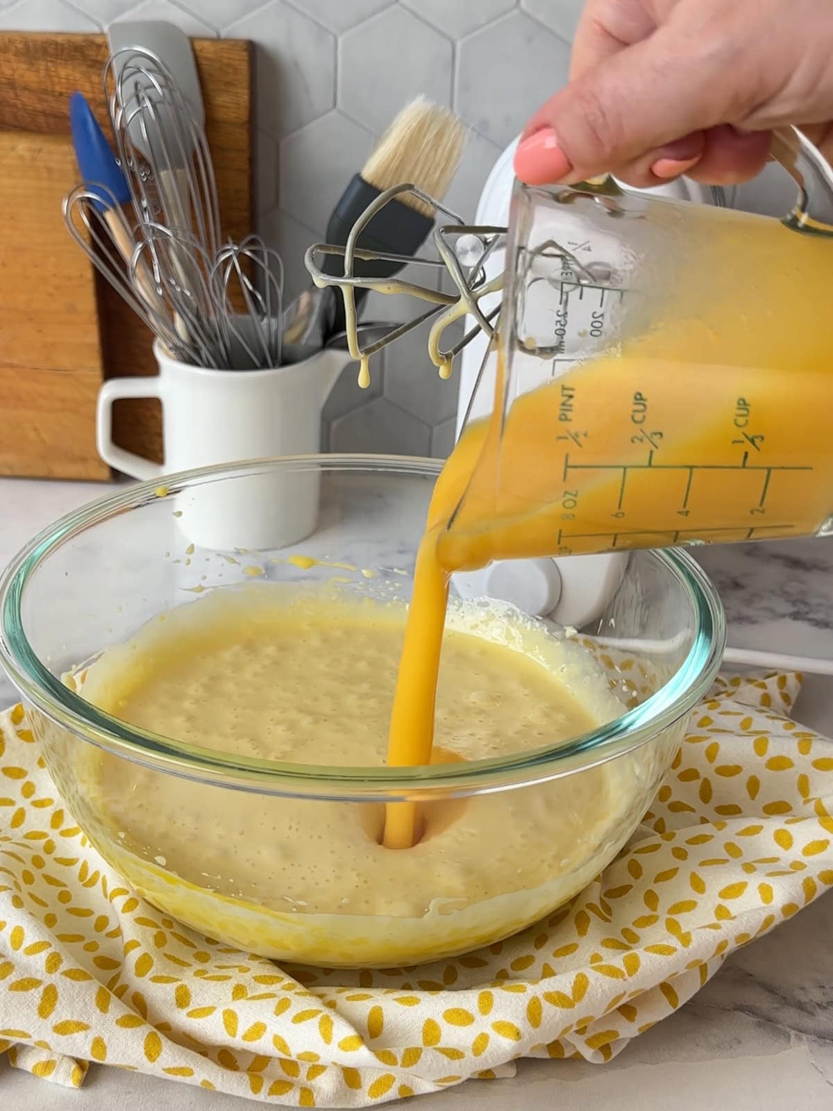 Pouring mango puree into pie filling in a bowl.