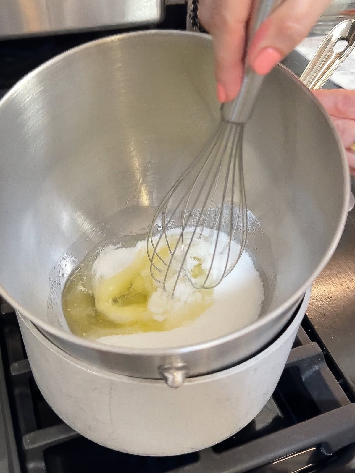 whisking together egg whites and sugar over a double boiler to make meringue.