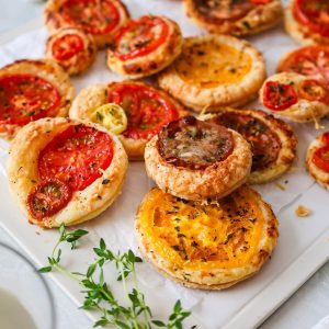 close up on mini tomato tarts with salt, pepper and fresh thyme