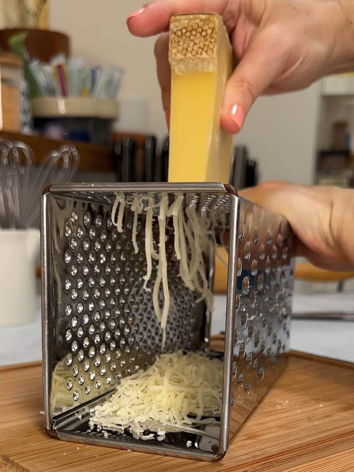 Grate gruyere cheese on the small holes of a box grater.