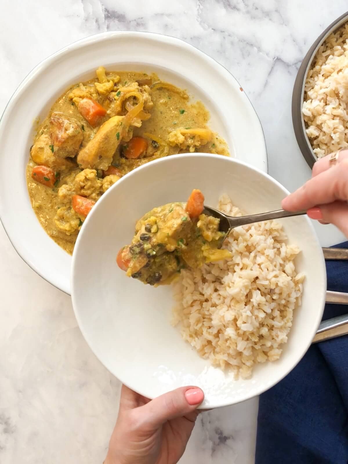 Close-up of a hearty serving of creamy chicken curry with cauliflower and carrots, ready to eat.