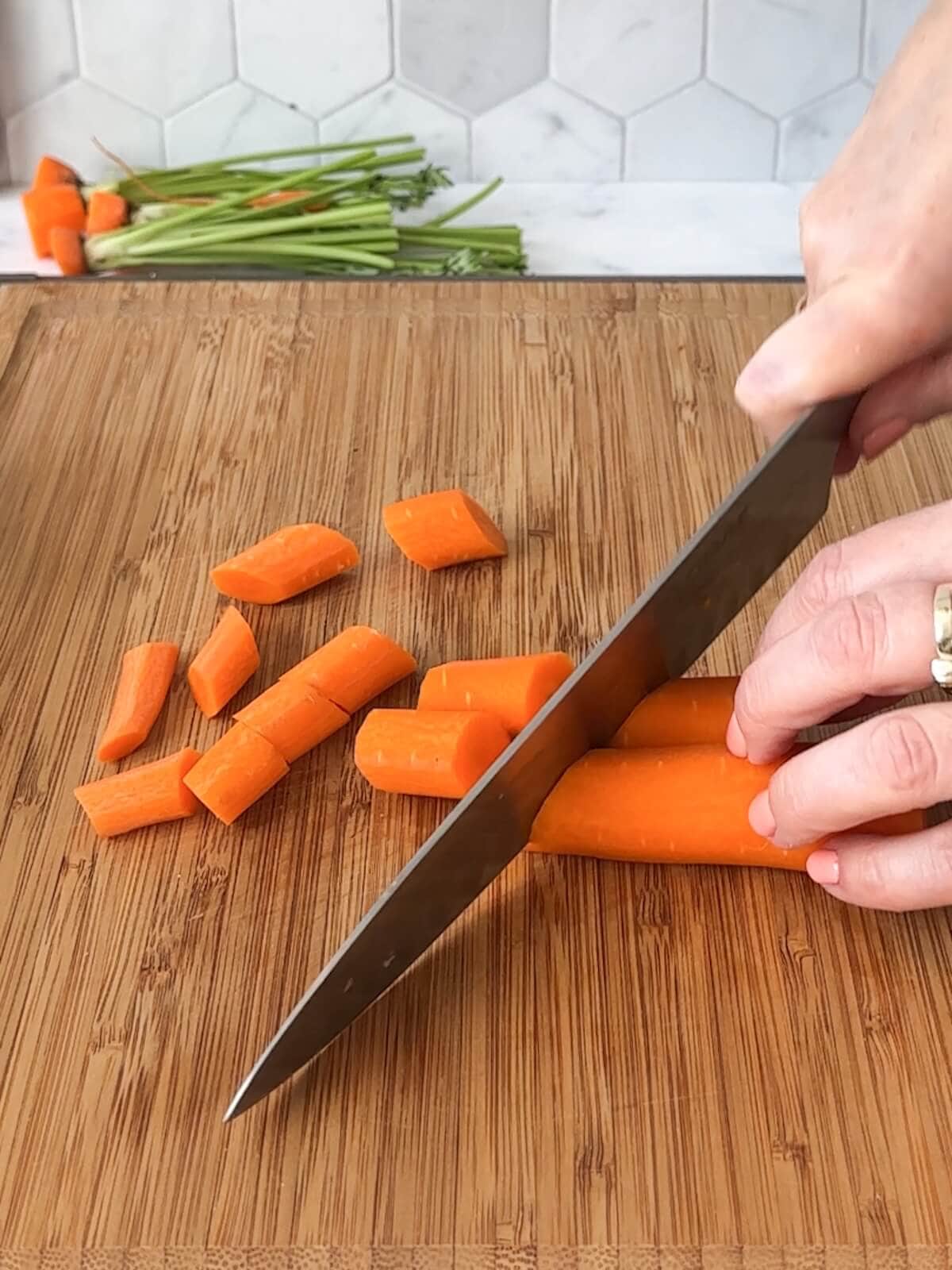 Cutting peeled carrots into pieces for curry.