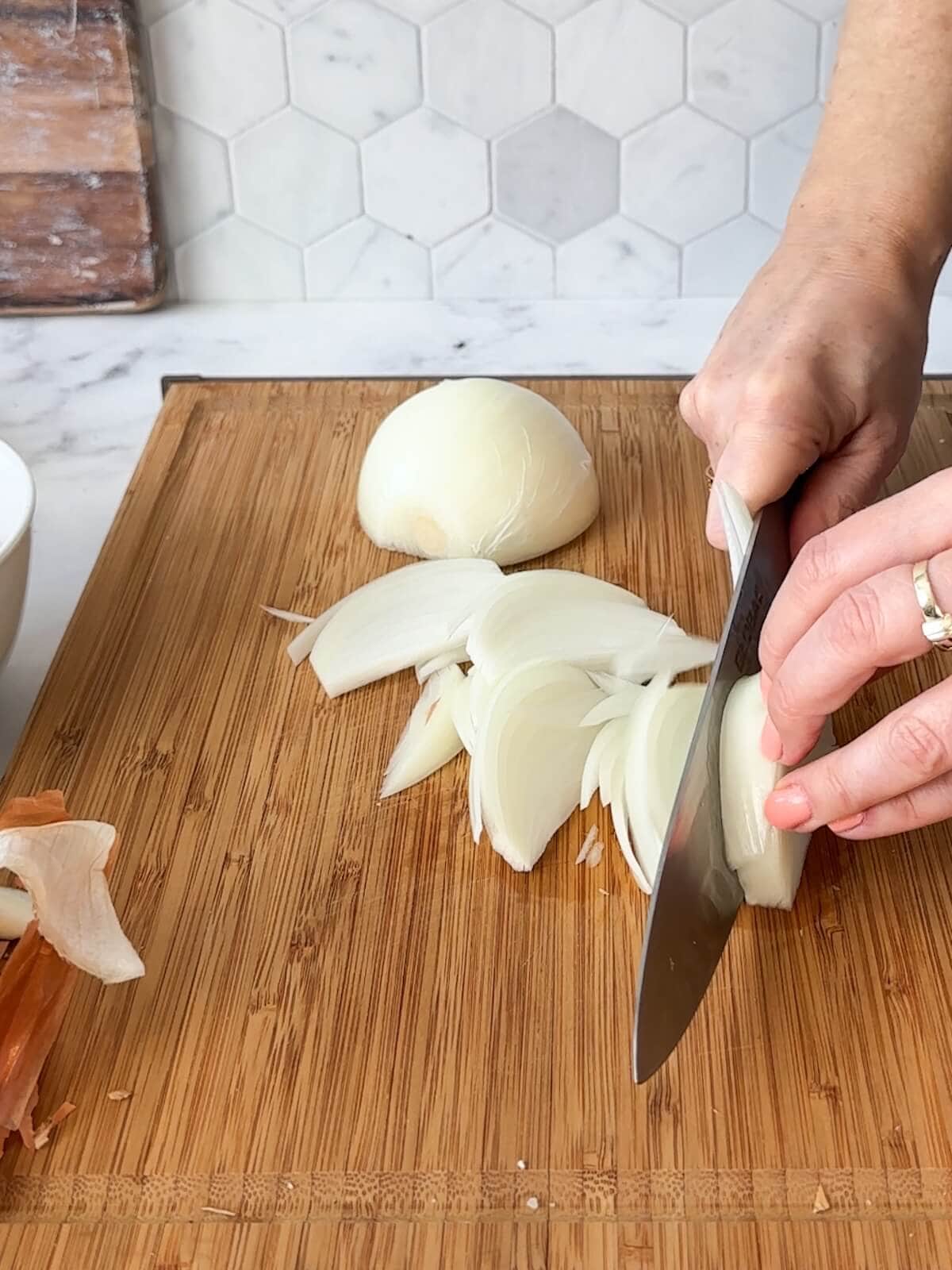 Slicing onions root to tip for curry.