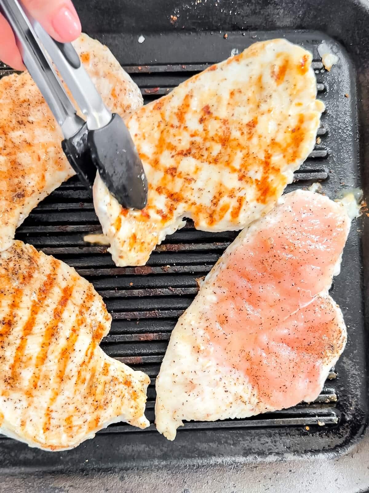 grilling 4 chicken cutlets on a grill pan