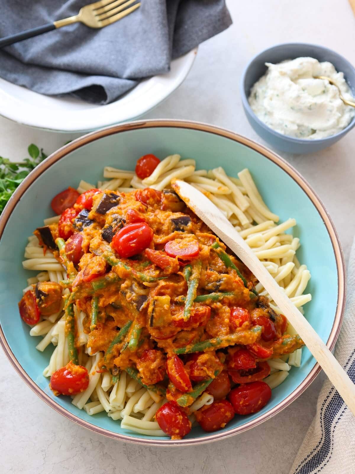 Stir sauce and vegetables with pasta for Italian Eggplant Pasta.