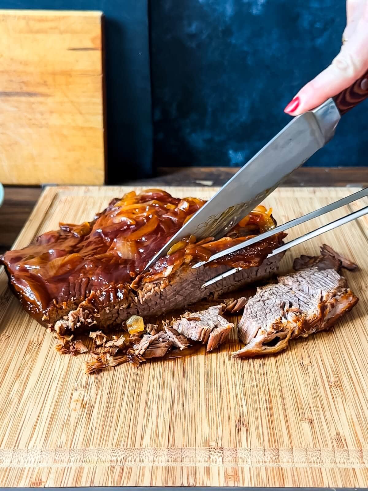 Slicing slow cooker brisket for sandwiches.