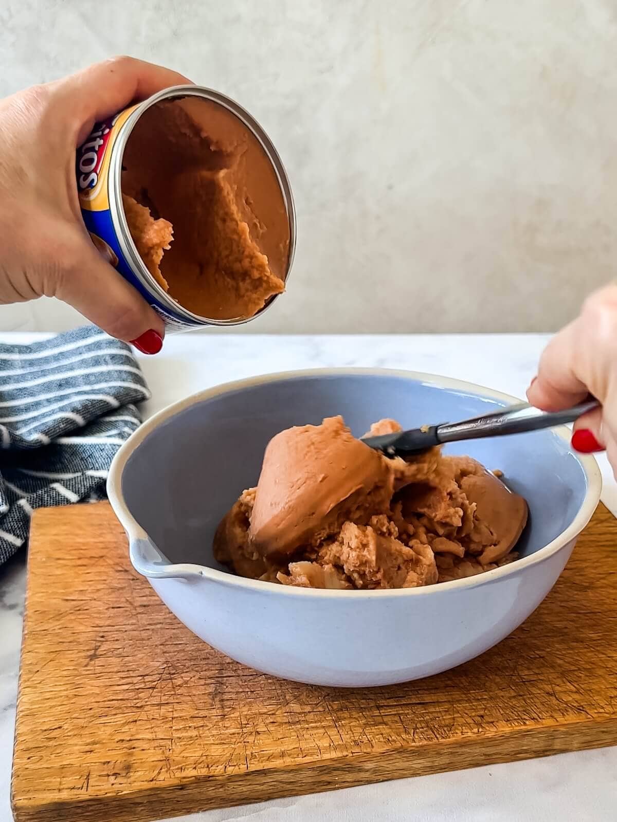Mix together bean dip and refried beans for the bottom layer of 7 layer dip.