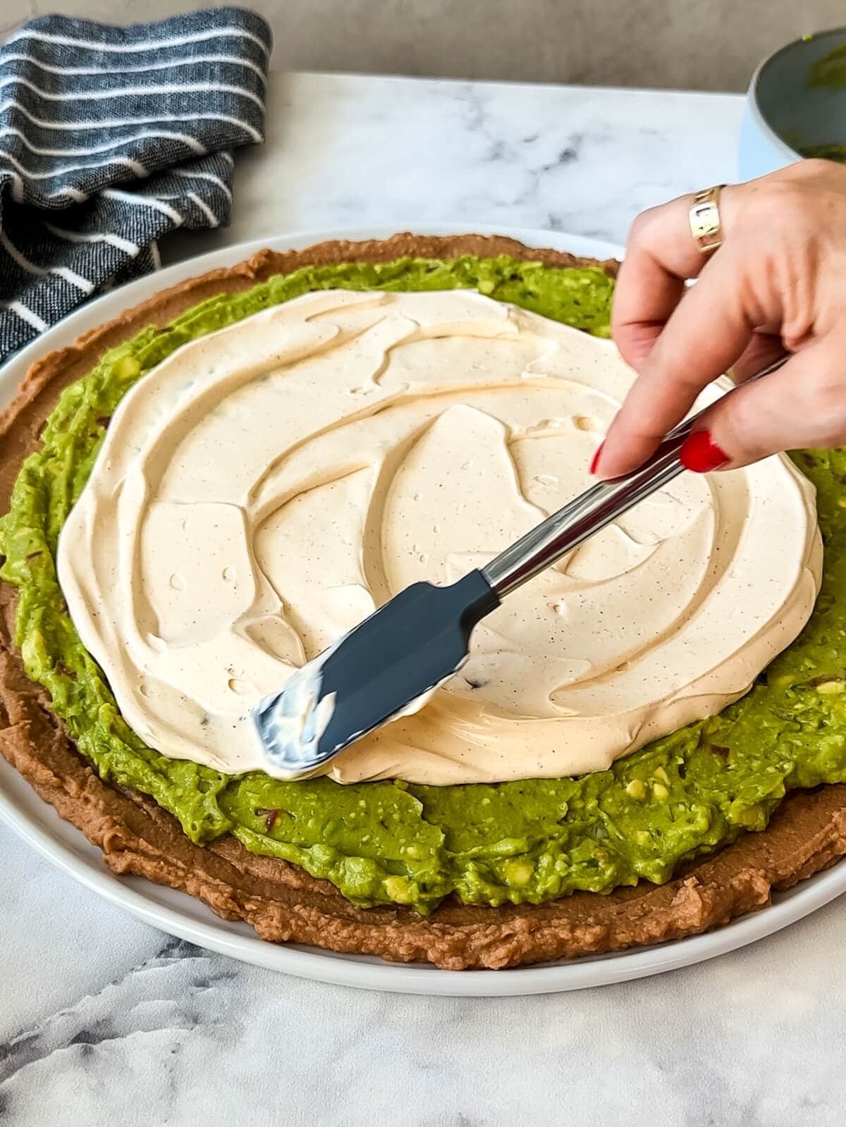 Spread the sour cream mixture on top of guacamole for 7 layer dip