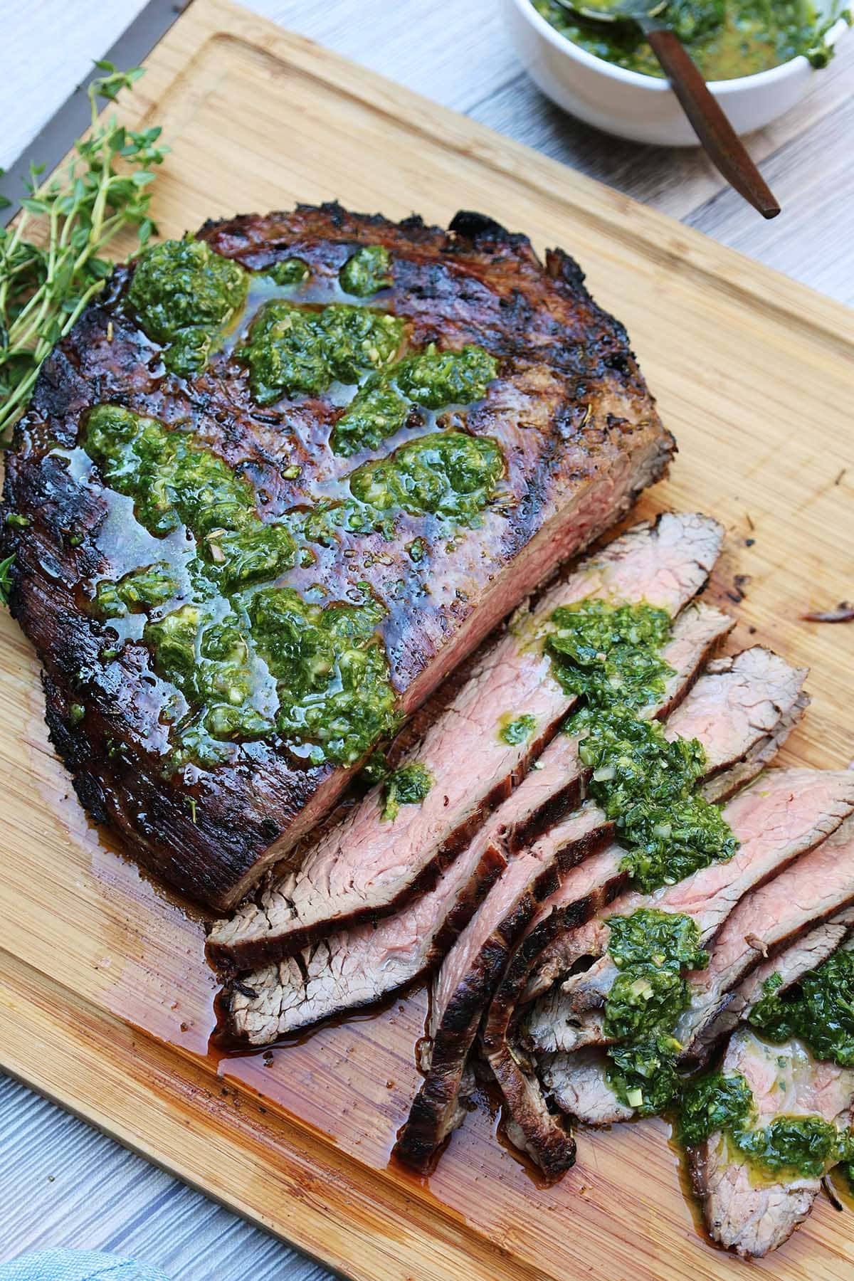 Overhead shot of grilled flank steak half slices with salsa