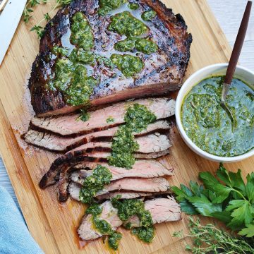 flank steak sliced with fresh salsa verde on top.