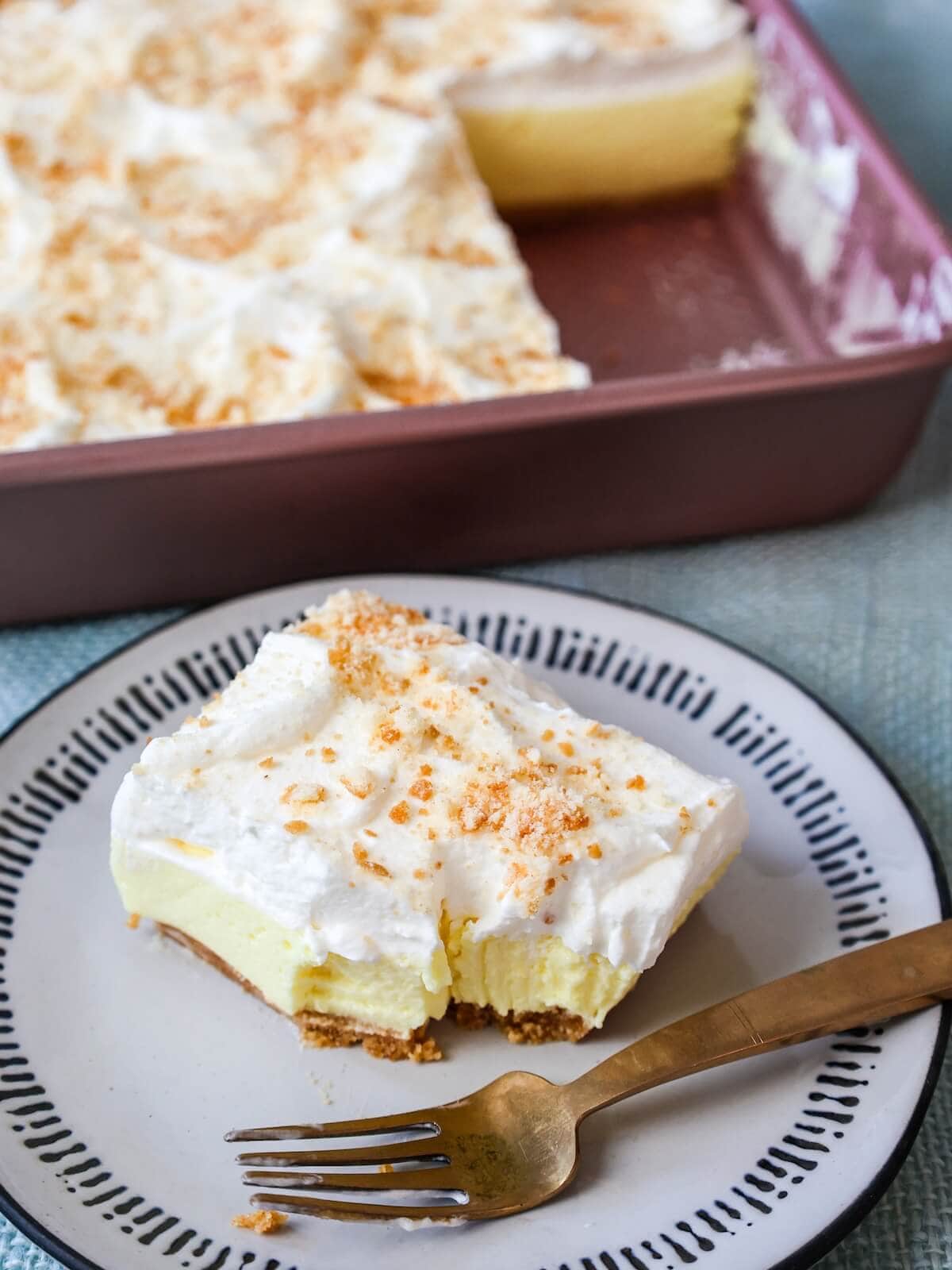 Square slice of lemon icebox dessert with a few bites eaten.