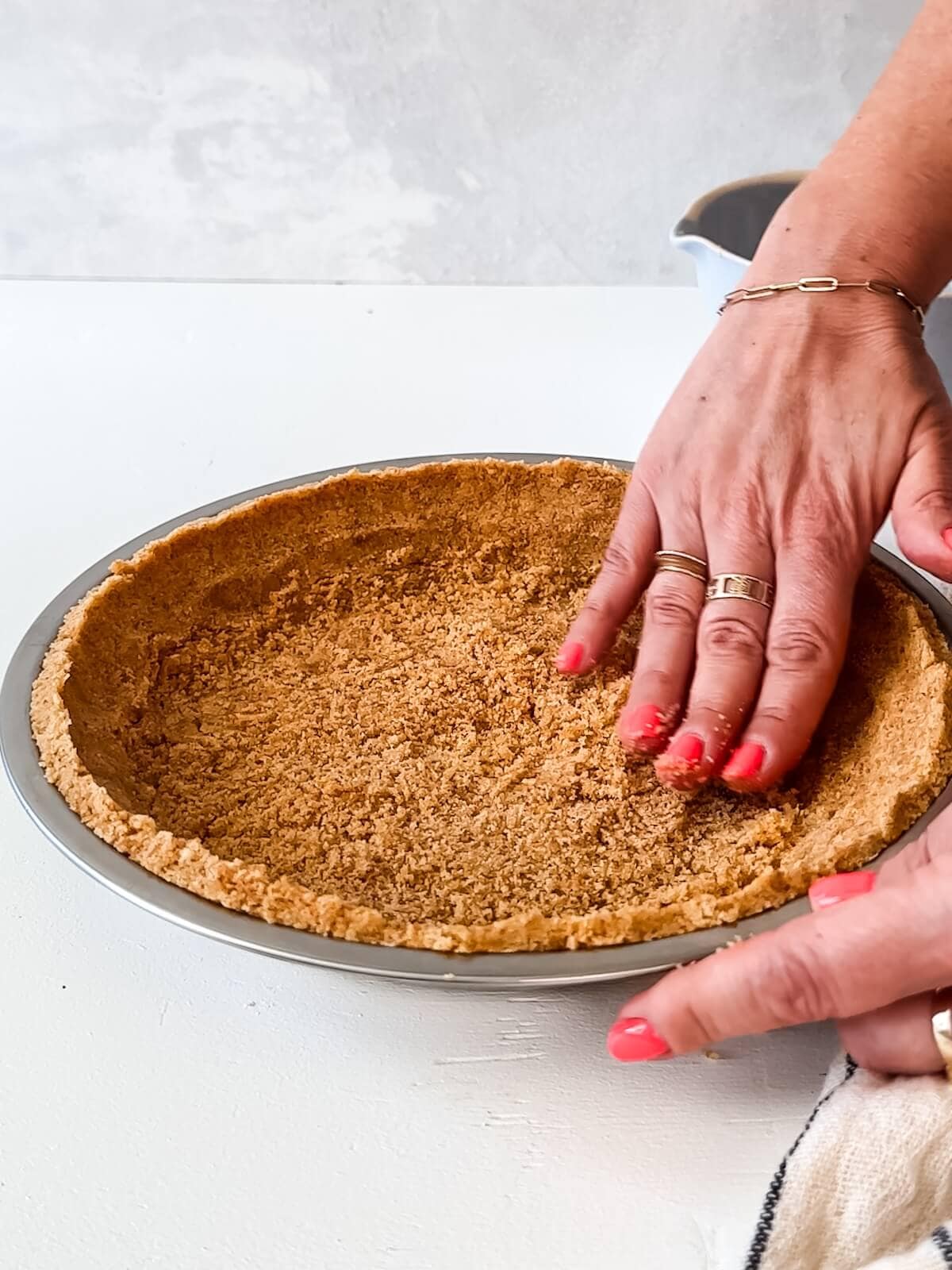 Pressing the cookie crust into a pie tin for lemon icebox pie.