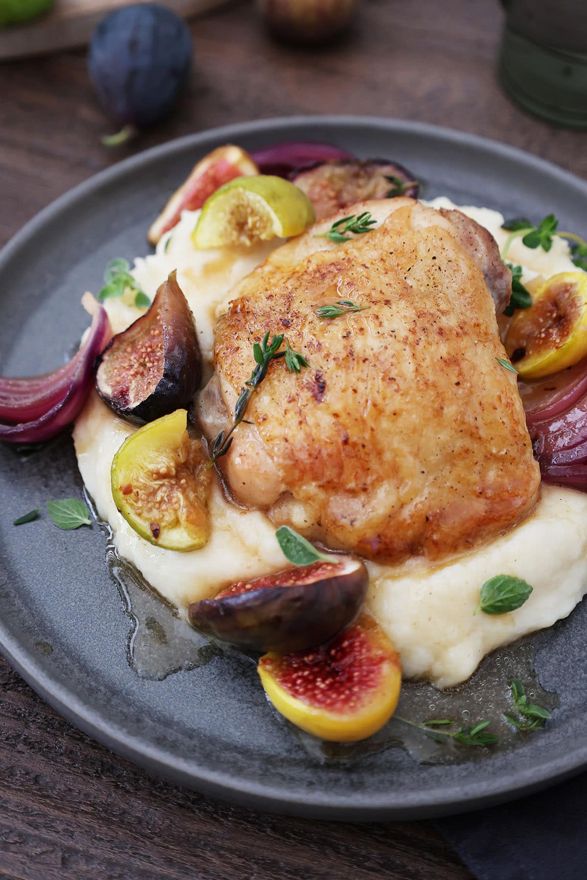 plate of mashed potatoes with honey braised chicken and figs on top
