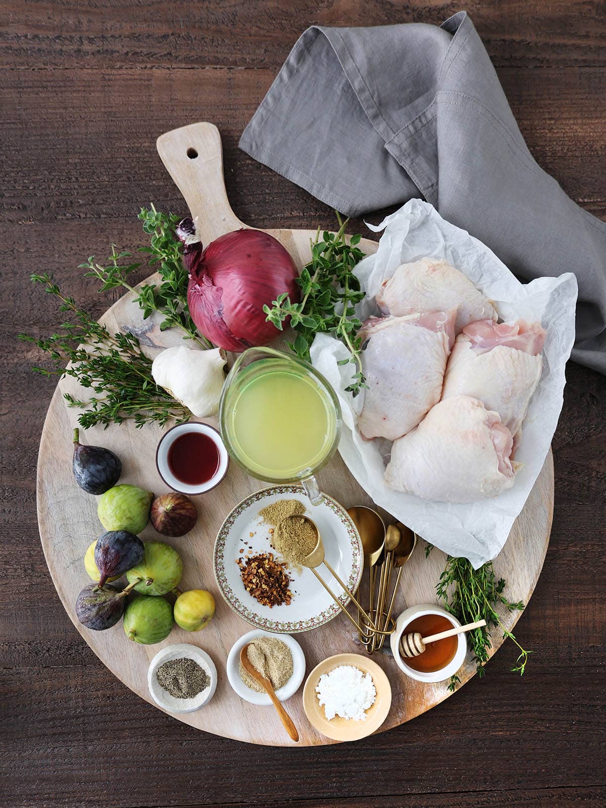 Ingredients for honey braised chicken and figs including spices, red onion, garlic, and herbs.