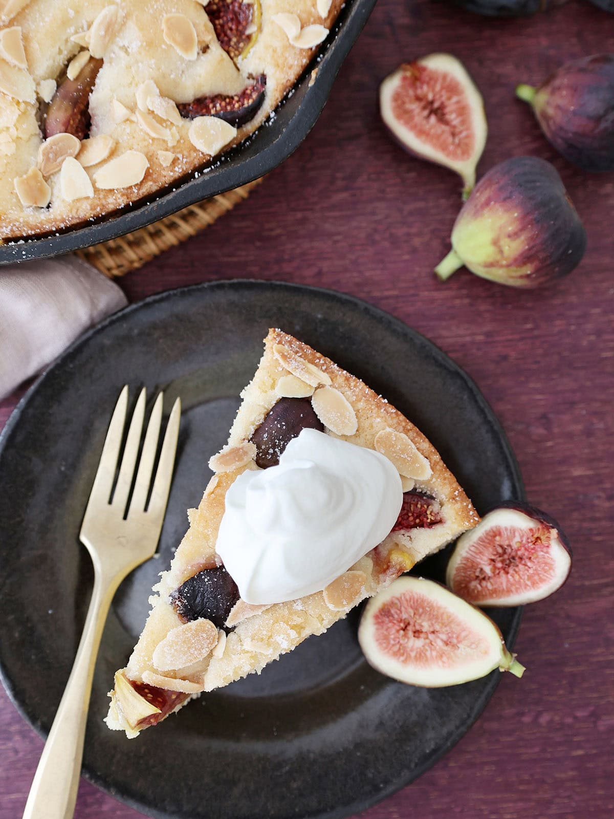 looking down on a slice of fig almond snack cake with whipped cream.
