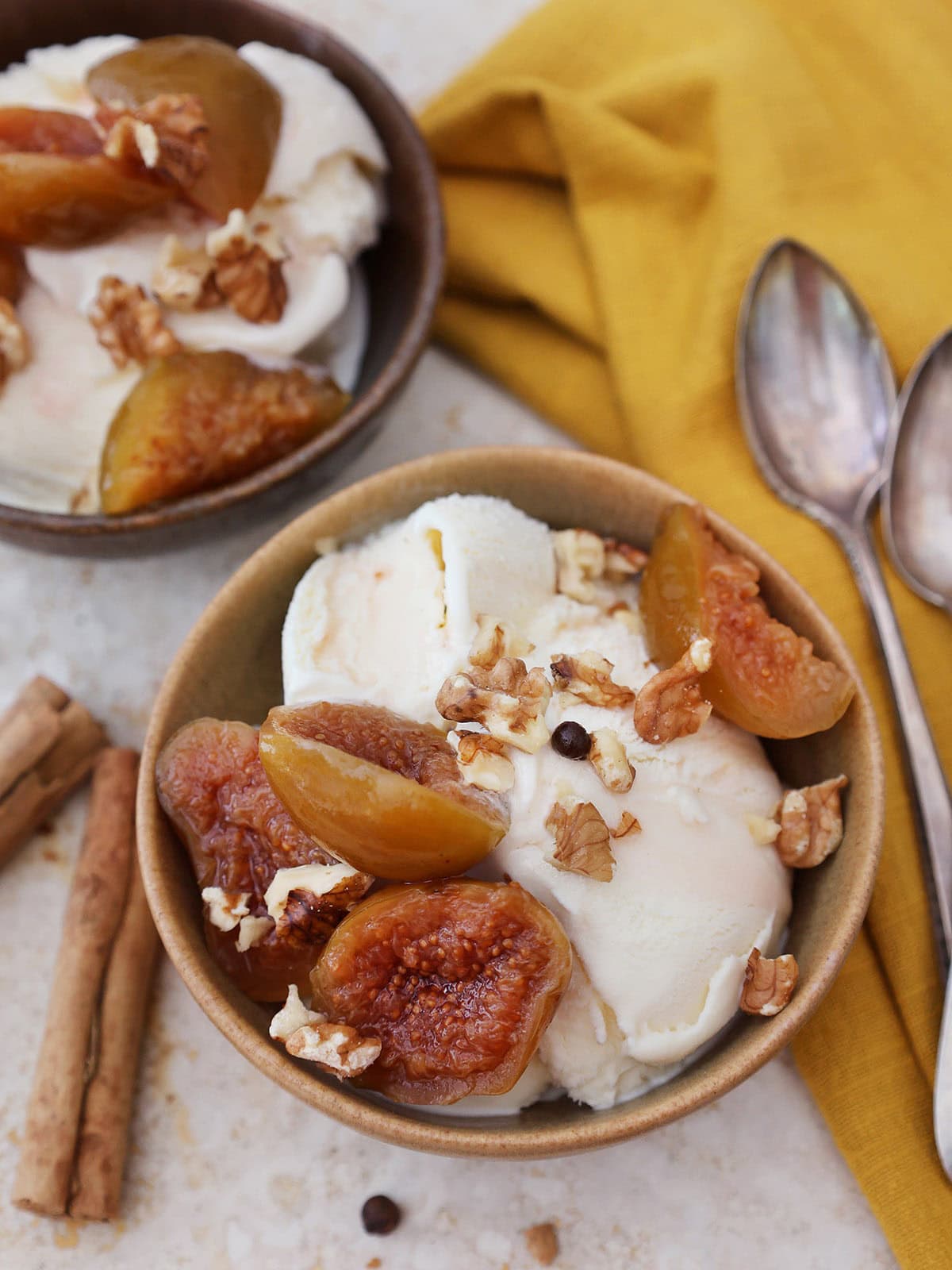 preserved figs in syrup on top of ice cream in a bowl with walnuts