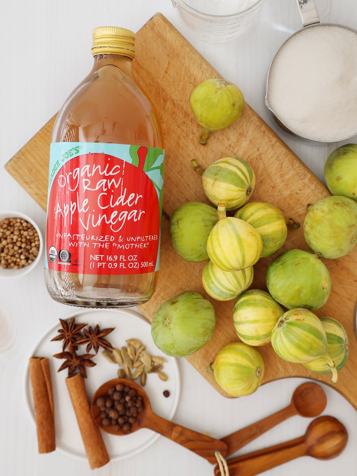 Ingredients for figs in syrup including apple cider vinegar, sugar, and spices.